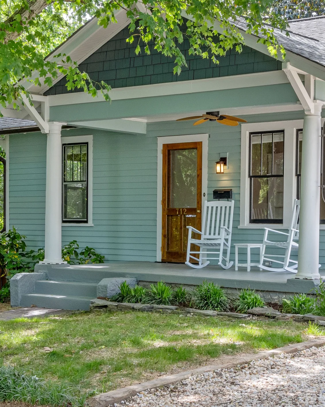 A craftsman bungalow with rocking chairs on the front porch